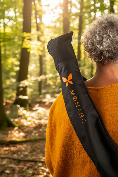 Marcheuse de dos en forêt portant la housse de transport MØNARC® en bandoulière